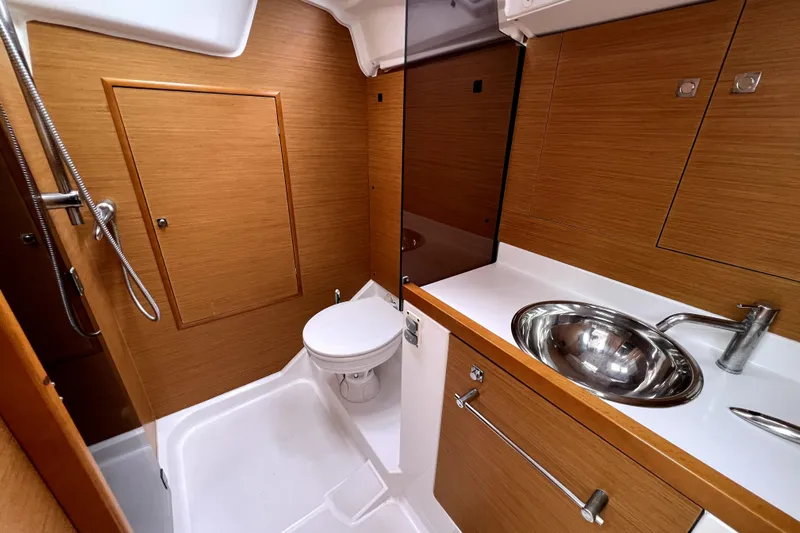Knot Behaving Yacht Photos Pics Modern bathroom in 2014 Jeanneau Sun Odyssey 379 yacht with wood paneling and stainless steel sink.