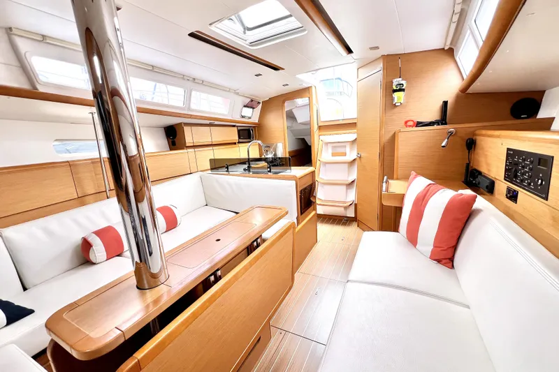 Knot Behaving Yacht Photos Pics Interior of 2014 Jeanneau Sun Odyssey 379 sailboat with modern wood finish and white seating.