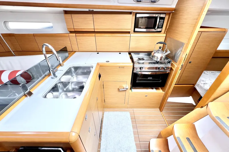 Knot Behaving Yacht Photos Pics Modern kitchen interior of 2014 Jeanneau Sun Odyssey 379 yacht with wood finish and appliances.