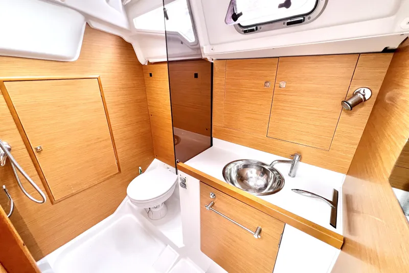 Knot Behaving Yacht Photos Pics 2014 Jeanneau Sun Odyssey 379 yacht bathroom with modern fixtures and wooden cabinetry.