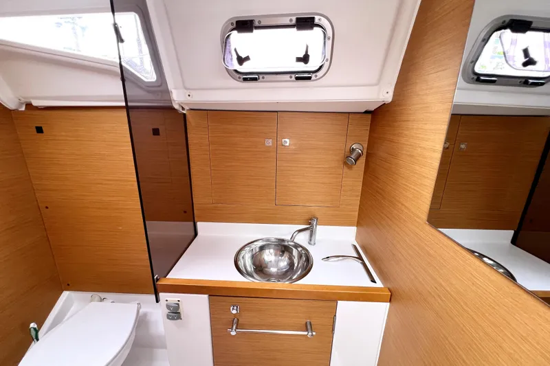 Knot Behaving Yacht Photos Pics Modern bathroom interior of 2014 Jeanneau Sun Odyssey 379 yacht, featuring wood paneling and stainless steel sink.