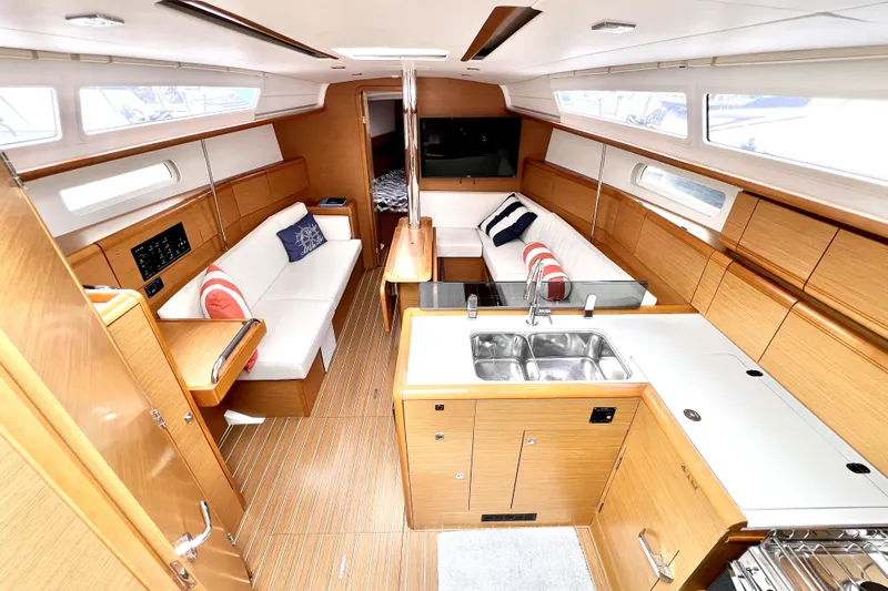 Knot Behaving Yacht Photos Pics Interior of 2014 Jeanneau Sun Odyssey 379 yacht with modern kitchen and seating area.