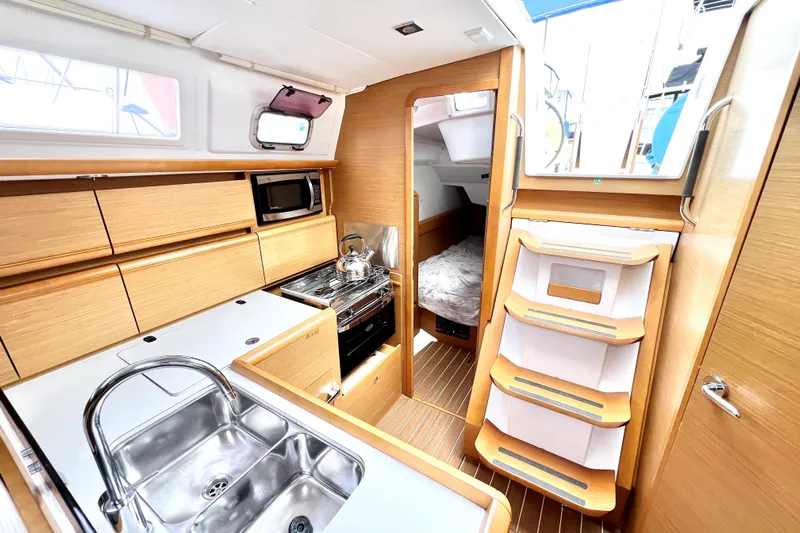 Knot Behaving Yacht Photos Pics Interior of 2014 Jeanneau Sun Odyssey 379 sailboat, featuring modern kitchen and cozy cabin.