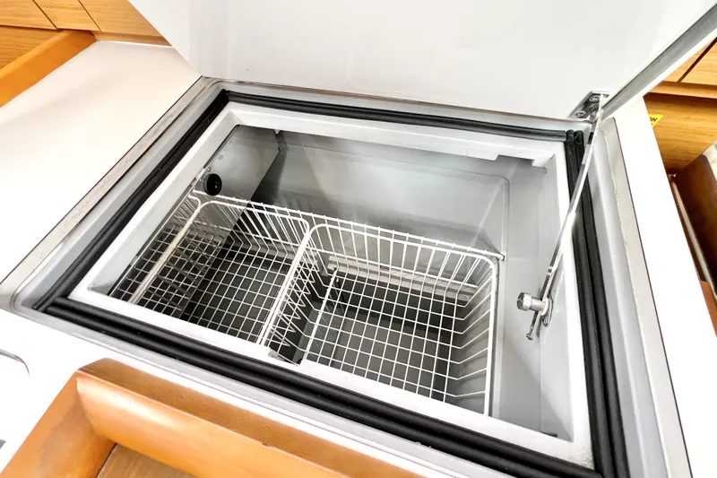 Knot Behaving Yacht Photos Pics Open refrigerator compartment on 2014 Jeanneau Sun Odyssey 379 yacht, featuring wire baskets.