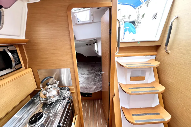 Knot Behaving Yacht Photos Pics Interior of 2014 Jeanneau Sun Odyssey 379 sailboat, featuring kitchen and cabin entry.