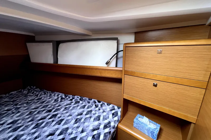 Knot Behaving Yacht Photos Pics Cozy cabin interior of 2014 Jeanneau Sun Odyssey 379 sailboat with wood finish and bed.