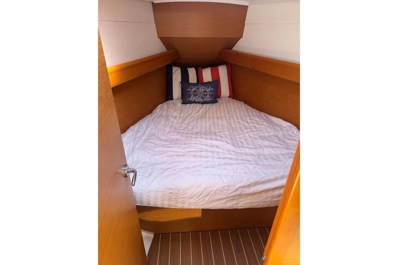 Knot Behaving Yacht Photos Pics Cozy cabin interior of 2014 Jeanneau Sun Odyssey 379 sailboat with striped pillows.