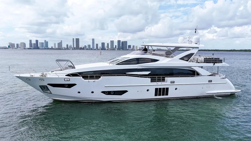  Yacht Photos Pics 2017 Azimut 95 Raised Pilothouse yacht on calm water with city skyline backdrop.