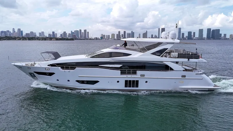  Yacht Photos Pics Luxury 2017 Azimut 95 Raised Pilothouse yacht cruising near city skyline.
