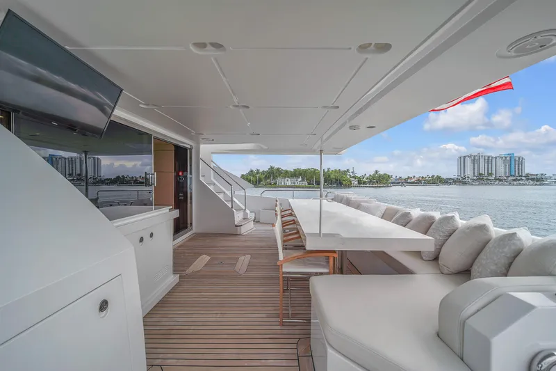  Yacht Photos Pics Luxurious 2017 Azimut 95 Raised Pilothouse yacht deck with seating, table, and scenic waterfront view.