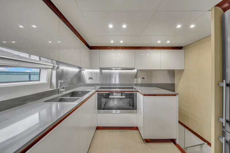  Yacht Photos Pics Modern kitchen interior on 2017 Azimut 95 Raised Pilothouse yacht, featuring sleek cabinetry and stainless steel appliances.