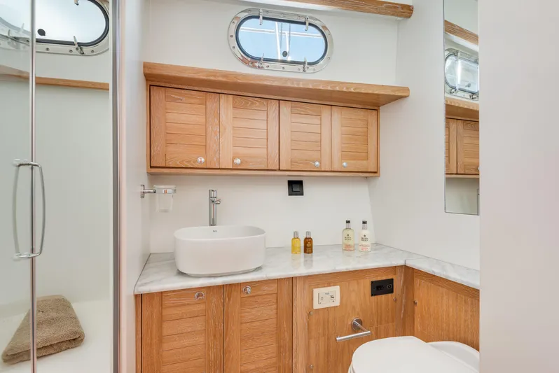  Yacht Photos Pics Luxurious bathroom in 2025 Sasga Yachts Menorquin 55 Flybridge with wooden cabinetry and modern fixtures.