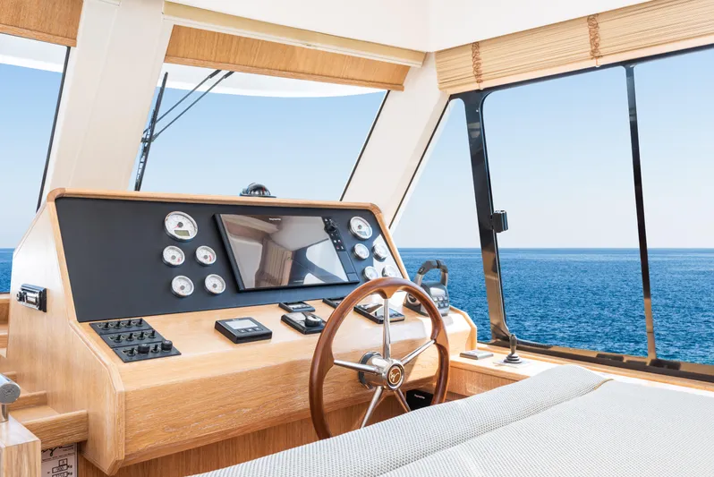  Yacht Photos Pics 2025 Sasga Yachts Menorquin 55 Flybridge helm with ocean view, featuring modern controls and wooden accents.