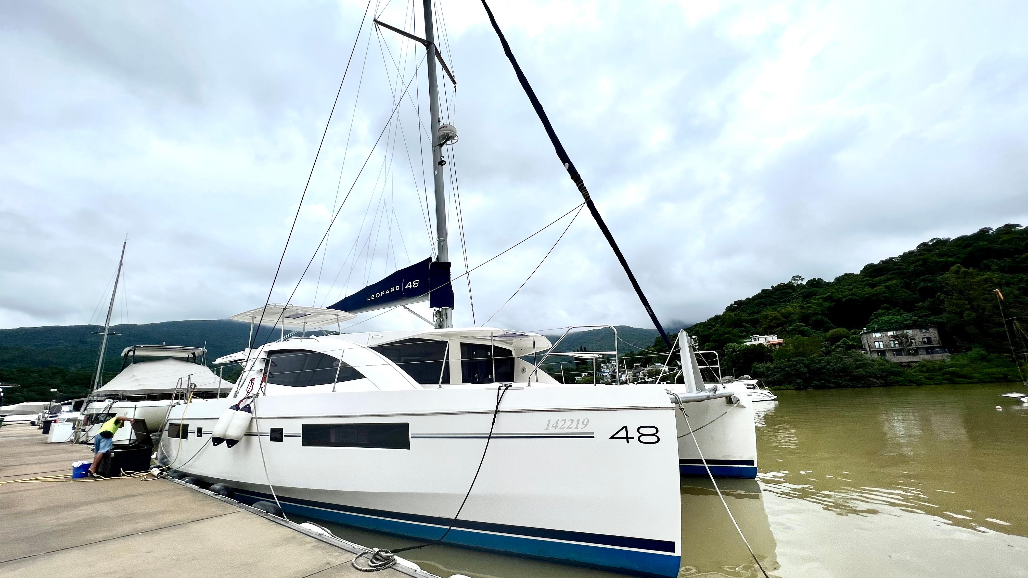 Leopard 48 catamaran docked at marina, 2015 model, overcast sky.