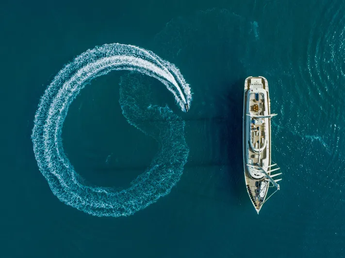 Aresteas Yacht Photos Pics Aerial view of 2017 Custom Yildizlar yacht with circular wake pattern in blue water.