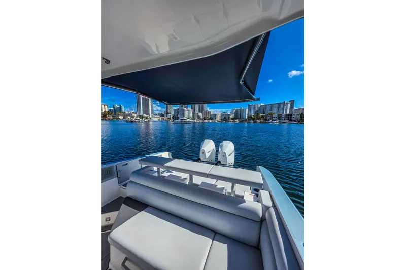 Yacht Photos Pics 2022 Aviara AV32 OB boat with city skyline view, featuring comfortable seating and twin outboard engines.
