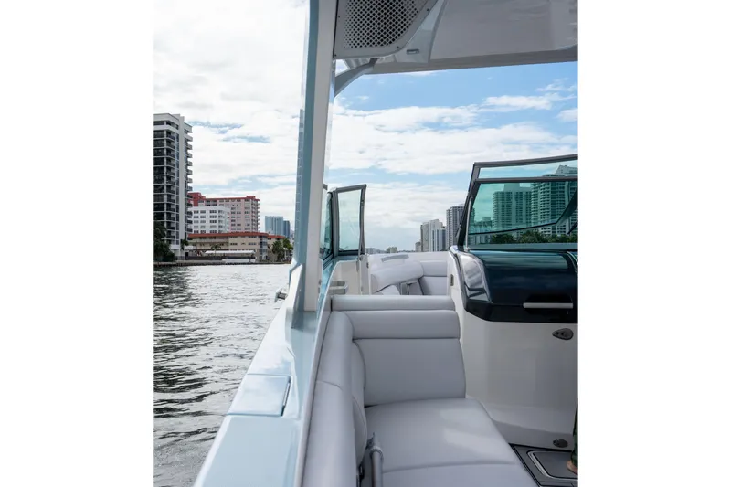  Yacht Photos Pics 2022 Aviara AV32 OB boat cruising near city skyline, featuring luxurious seating and modern design.