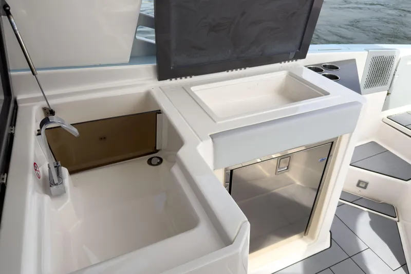  Yacht Photos Pics 2022 Aviara AV32 OB boat kitchen area with sink, storage, and stainless steel fridge.