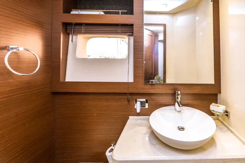 Waterfront III Yacht Photos Pics Luxurious bathroom interior of 2014 Sea Ray 510 Fly yacht with modern sink and wood accents.
