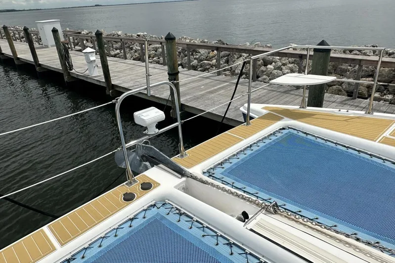 La De Dah Yacht Photos Pics 2007 Manta 44 Power Cat docked, featuring blue netting and wooden deck details.