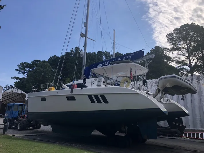 Adventure Yacht Photos Pics Broadblue 435 catamaran from 2010 on land, surrounded by trees and clear sky.