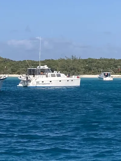 Adventure Yacht Photos Pics Broadblue 435 catamaran anchored near a tropical shoreline, 2010 model.