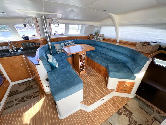 Adventure Yacht Photos Pics Spacious interior of 2010 Broadblue 435 catamaran with blue seating and wooden accents.