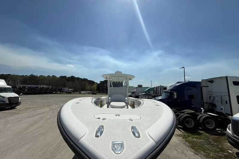 Cut Loose Yacht Photos Pics 2013 Yellowfin 32 Offshore boat in a parking lot under clear blue sky.