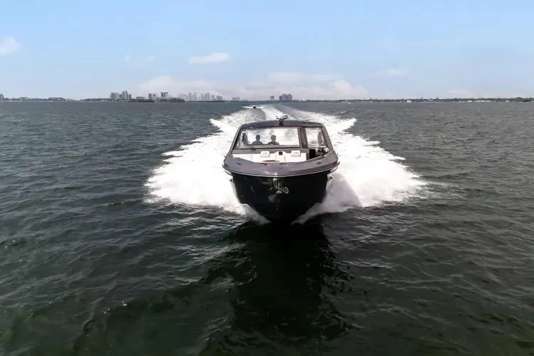  Yacht Photos Pics 2023 Cruisers 42 GLS OB boat cruising on open water, city skyline in background.