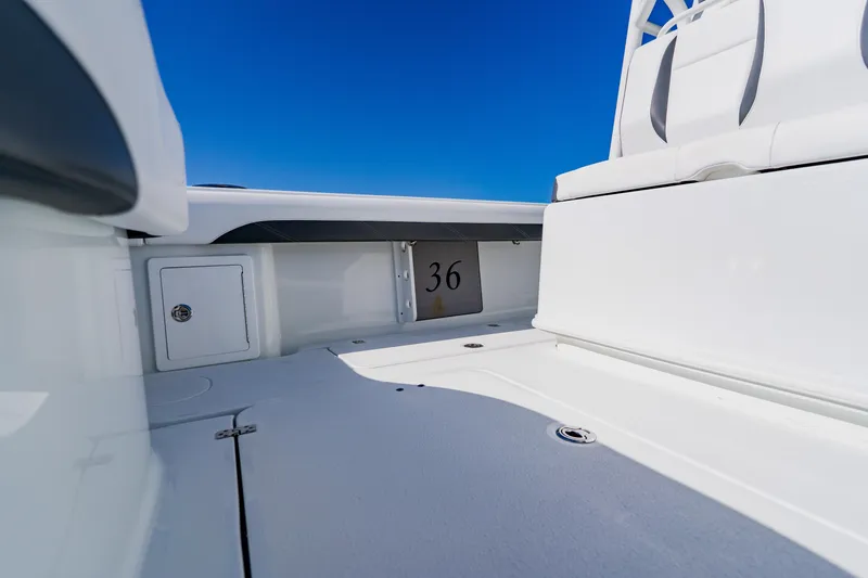  Yacht Photos Pics 2025 Yellowfin 36 Offshore boat interior with seating and storage, under clear blue sky.