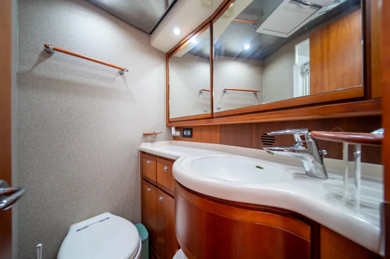 Jobsite Yacht Photos Pics Luxurious bathroom in a 2009 Bertram 630 yacht with wooden cabinetry and modern fixtures.