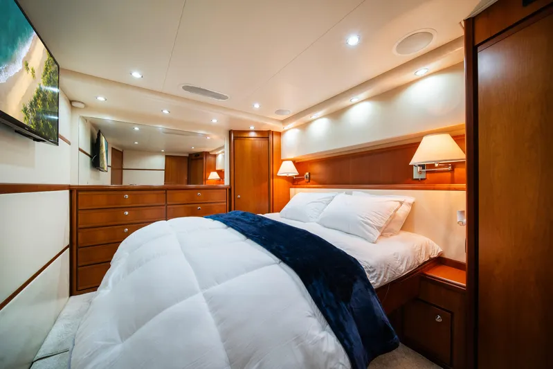 Jobsite Yacht Photos Pics Luxurious bedroom interior of 2009 Bertram 630 yacht with wooden cabinetry and cozy bedding.
