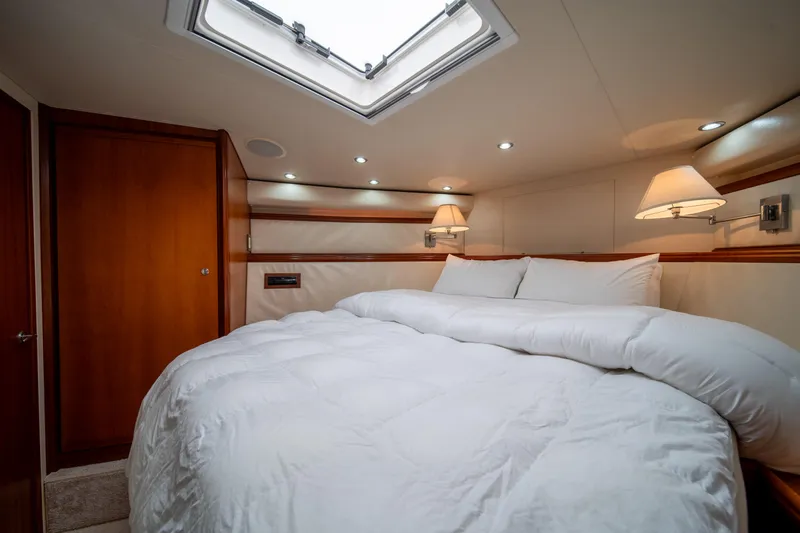 Jobsite Yacht Photos Pics Luxurious bedroom interior of a 2009 Bertram 630 yacht with skylight and cozy bedding.