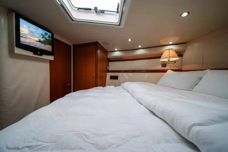 Jobsite Yacht Photos Pics Luxurious bedroom in a 2009 Bertram 630 yacht with TV and skylight.