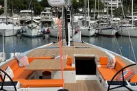 Luxurious 2022 Solaris 64 RS yacht with orange seating, docked in a marina.