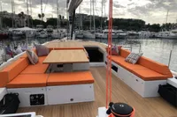Luxurious 2022 Solaris 64 RS yacht with orange seating, docked in a marina.