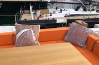 Luxury yacht Solaris 64 RS interior with orange seating and decorative pillows, 2022 model.