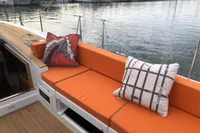 Orange cushioned seating on 2022 Solaris 64 RS yacht, docked at marina with boats.