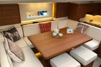 Luxurious interior of 2022 Solaris 64 RS yacht with cozy seating and elegant wooden table.