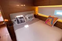 Luxurious bedroom interior of 2022 Solaris 64 RS yacht with modern design and cozy bedding.