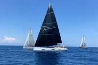Sailing yachts on open sea, featuring a 2022 Solaris 64 RS with black sails.
