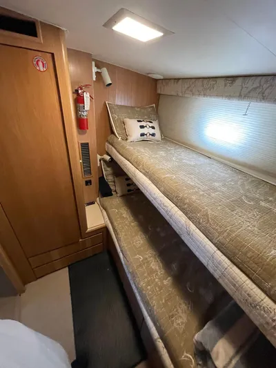 Lady Grace Yacht Photos Pics Interior of 1995 Hatteras 52 Motor Yacht with cozy bunk beds and wooden paneling.