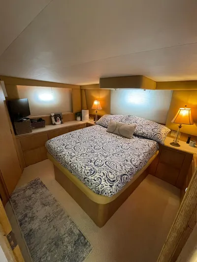 Lady Grace Yacht Photos Pics Cozy bedroom in 1995 Hatteras 52 Motor Yacht with elegant bedding and warm lighting.