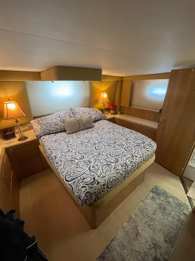 Lady Grace Yacht Photos Pics Luxurious bedroom interior of 1995 Hatteras 52 Motor Yacht with elegant bedding and warm lighting.
