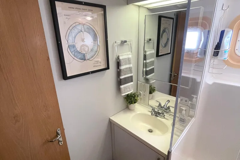 Lady Grace Yacht Photos Pics Bathroom interior of 1995 Hatteras 52 Motor Yacht with sink, mirror, and framed artwork.