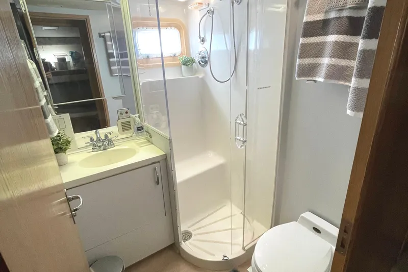 Lady Grace Yacht Photos Pics Bathroom interior of 1995 Hatteras 52 Motor Yacht with shower, sink, and toilet.