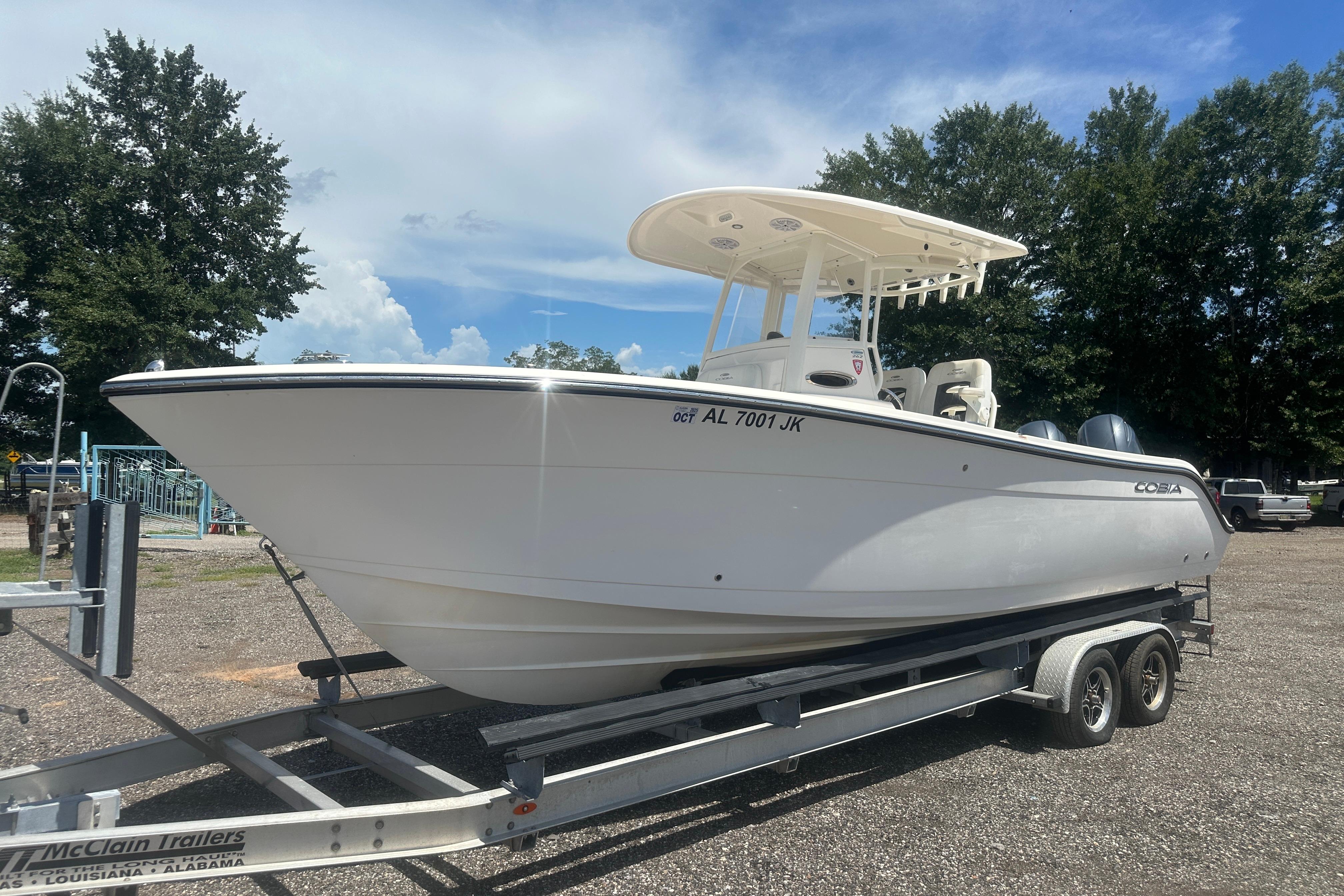 2023 Cobia 262 Center Console boat on trailer, parked outdoors under a clear sky.