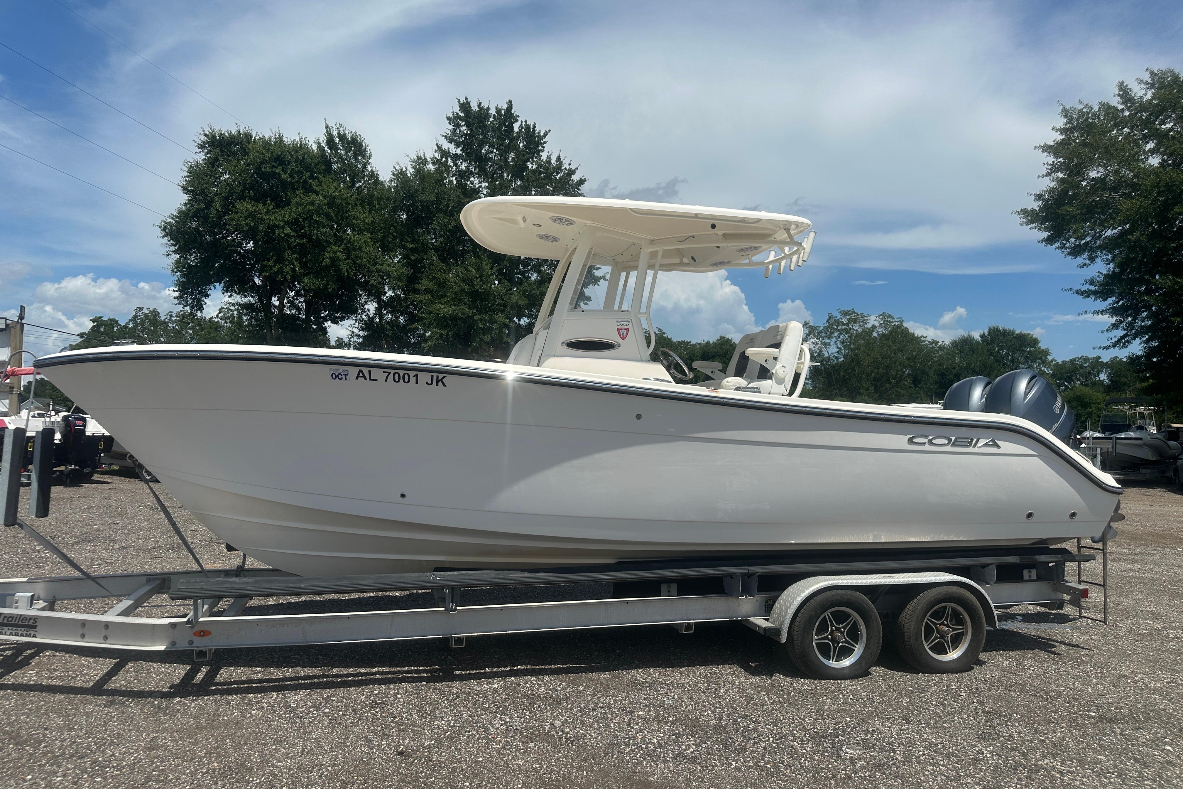 2023 Cobia 262 Center Console boat on trailer, parked outdoors under a clear sky.