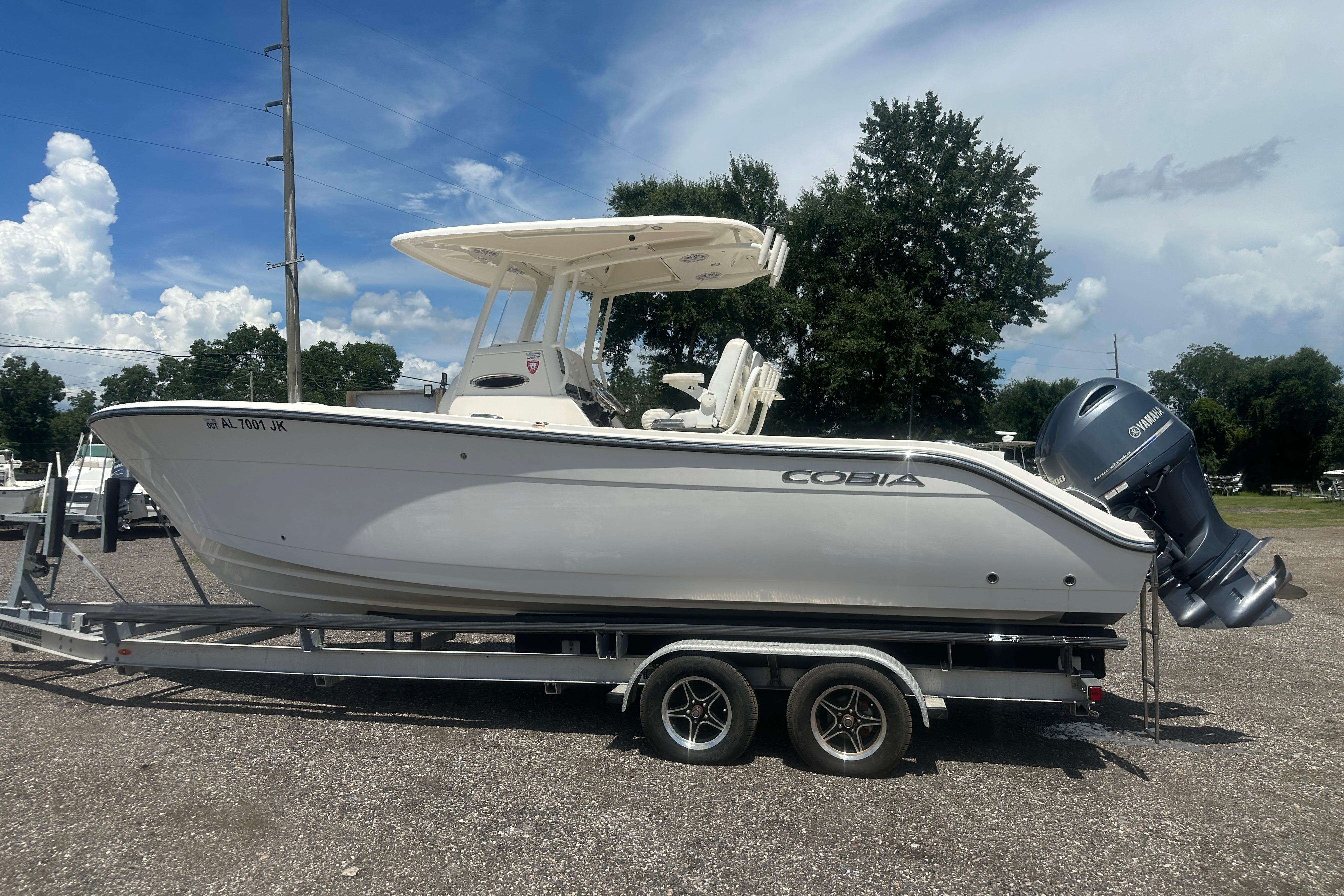2023 Cobia 262 Center Console boat on trailer under clear blue sky.