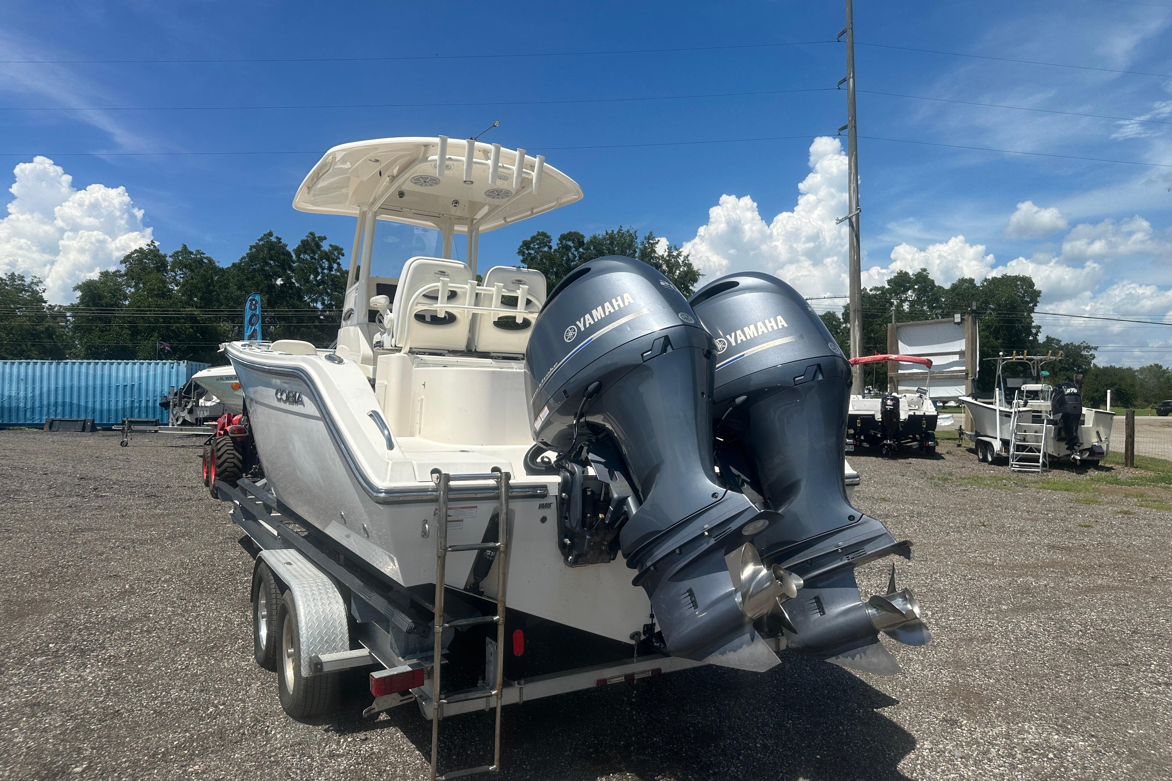 2023 Cobia 262 Center Console boat with dual Yamaha engines on a trailer.